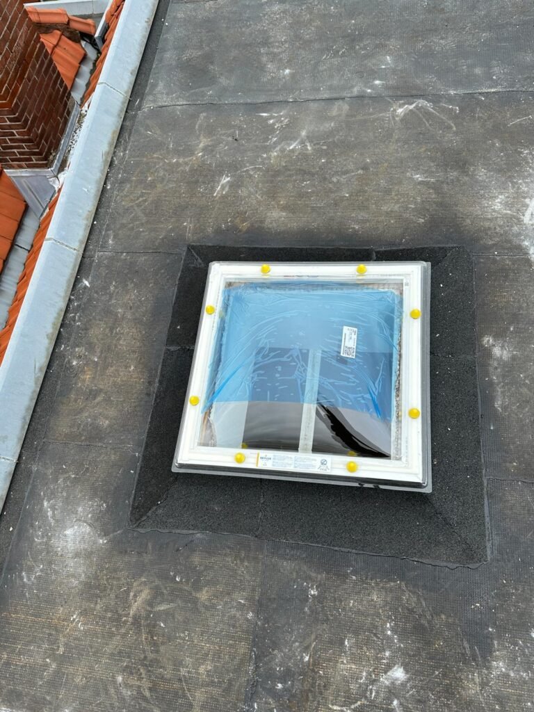 Lichtkoepel ingewerkt in een plat bitumen dak met loodslabbe