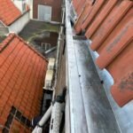 Nieuw aangebrachte zinken mastgoot langs een pannendak